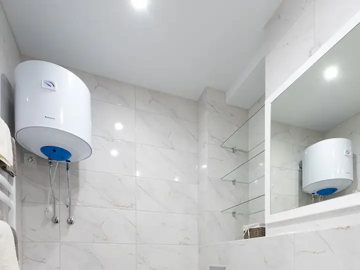 Electric water heater mounted on a bathroom wall
