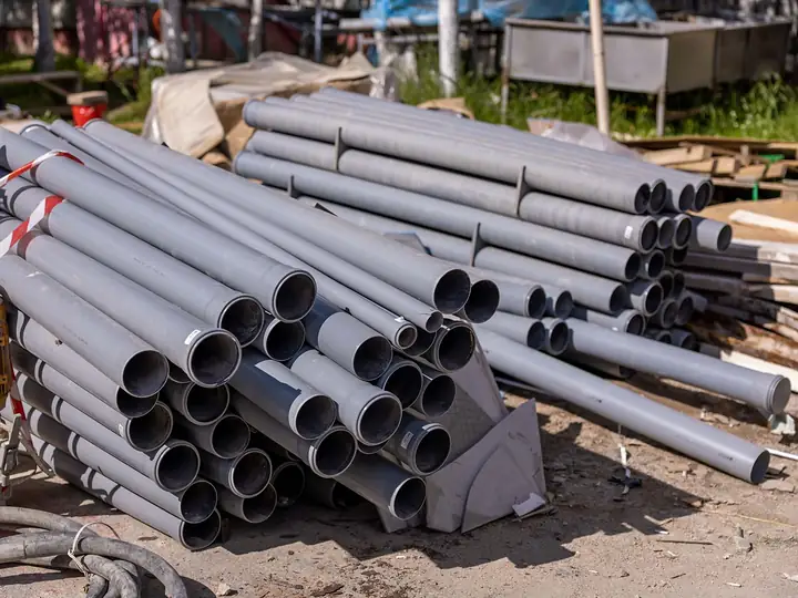 Stack of grey PVC water pipes ready for installation